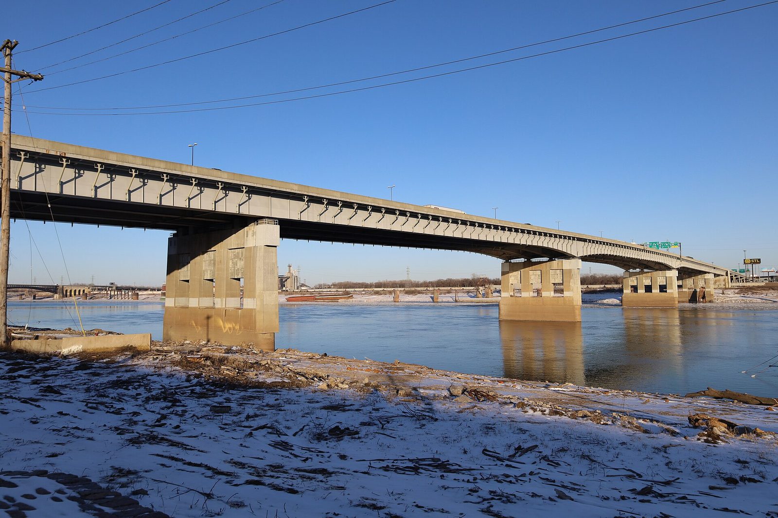 The Poplar Street Bridge at St. Louis on a clear winter day, interstate traffic on the deck, the Mississippi River and snowy bank below